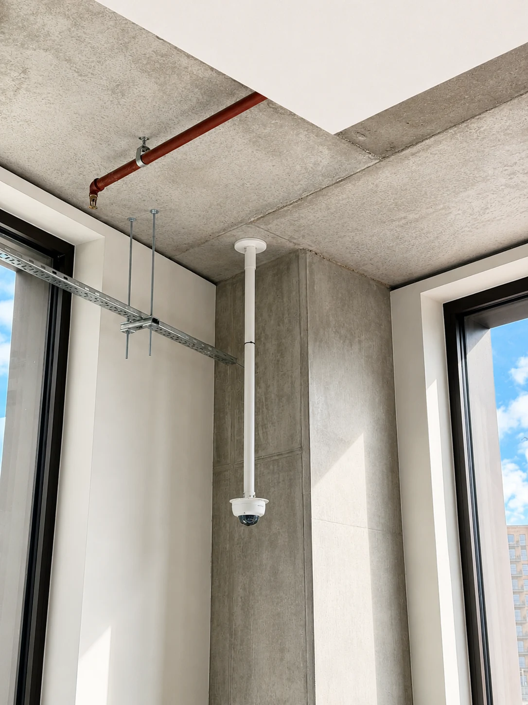 Ceiling-mounted dome CCTV camera in a modern commercial interior